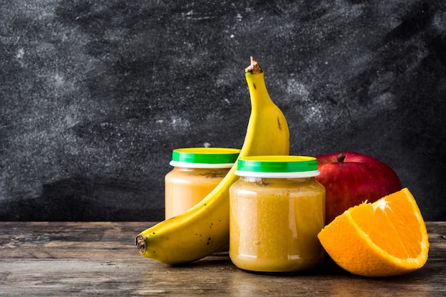 Tarro con puré de frutas en la mesa de madera