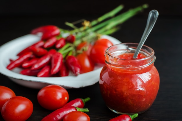 Foto tarro de salsa de tomate con ingredientes frescos