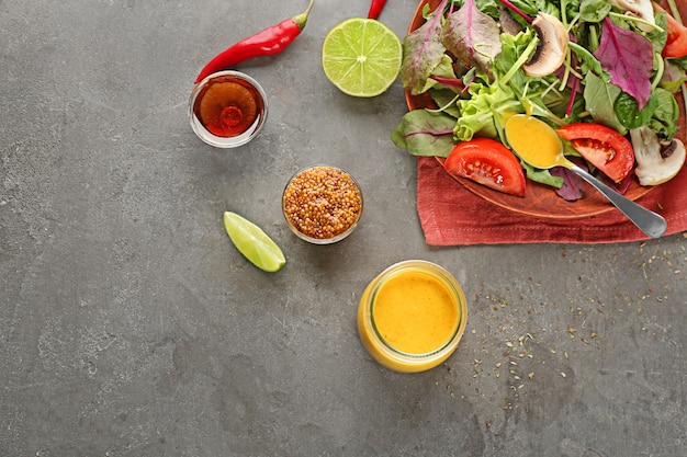 Tarro y salseras con sabrosas salsas para ensalada en la mesa