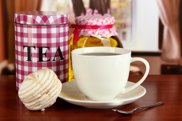 Tarro y taza de té en la mesa en la habitación