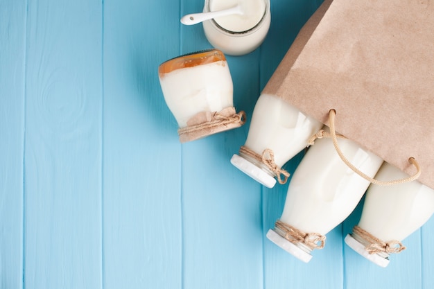 Foto tarros y botellas de leche en bolsa de papel.