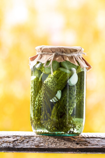 Tarros de verduras en escabeche: pepinos en un estante de madera