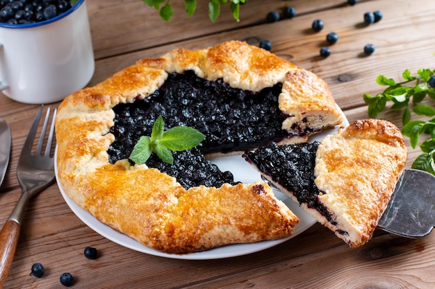 Tarta con arándanos frescos y cocidos sobre mesa de madera