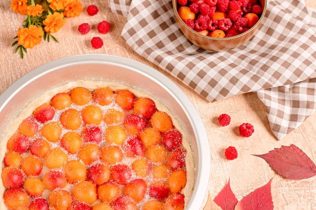 Tarta casera de albaricoque dulce delicioso servido con frambuesas en una mesa, vista superior