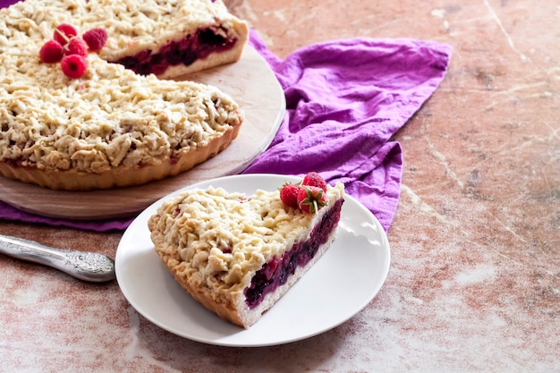 Tarta casera de berry shortcrust con crumble sobre tabla de madera