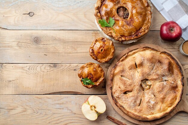 Tarta casera de carne y manzana con vegetación sobre fondo de madera