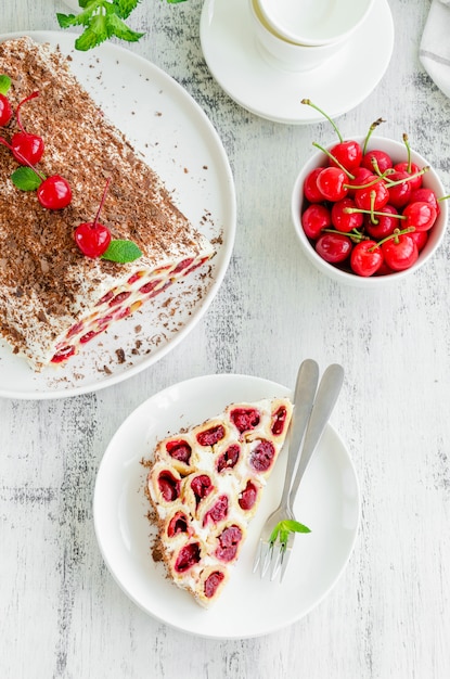 Tarta casera con cerezas, crema agria y chocolate en un plato blanco