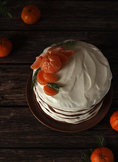 Tarta casera de chocolate con varias capas de crema blanca y mandarinas