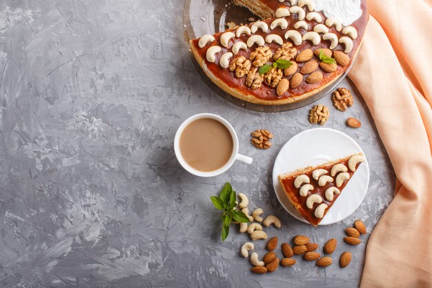 Tarta casera con crema de caramelo y nueces con taza de café en concreto gris