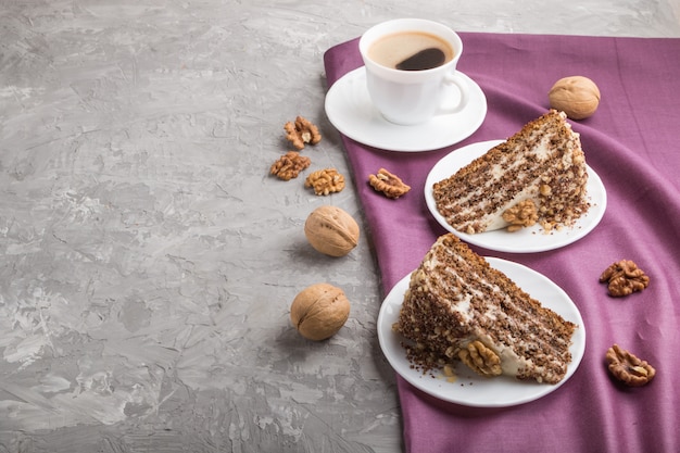 Tarta casera con crema de leche y nueces con taza de café sobre hormigón gris