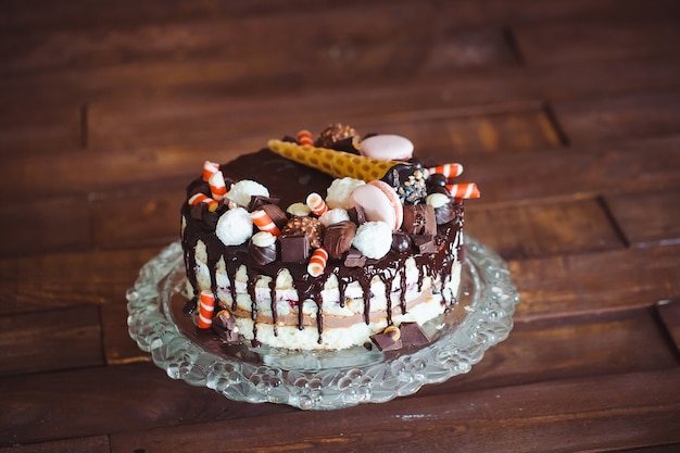 Tarta casera decorada con dulces, macarrones y gofres.