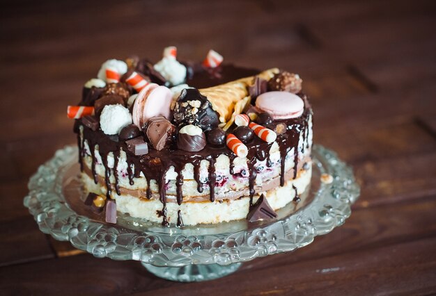 Tarta casera decorada con dulces, macarrones y gofres.