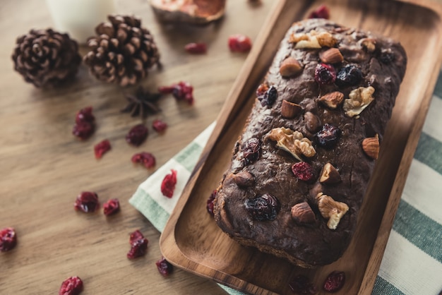 Tarta casera fresca de frutos secos de chocolate con nueces en una placa de madera