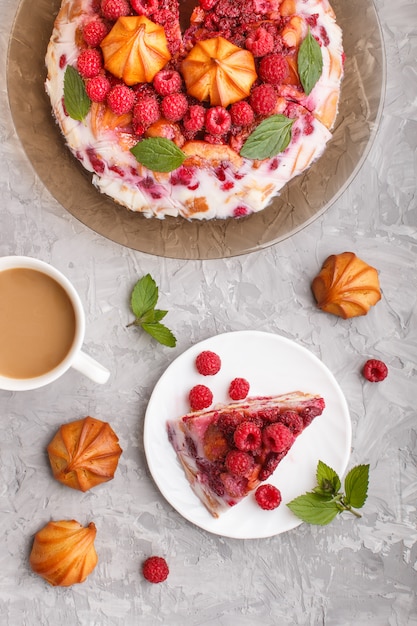 Tarta casera de gelatina con leche, galletas y frambuesa con taza de café, vista superior.