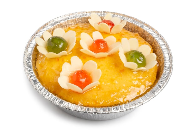 Tarta casera de mandarina con flores decoradas en un papel de estaño aislado en blanco