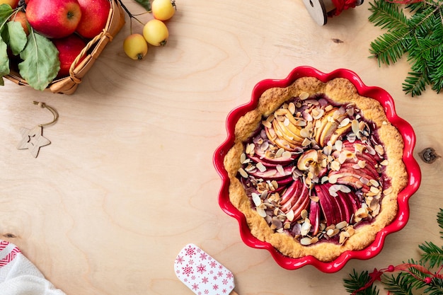 Tarta casera con mermelada de arándanos y manzanas rojas frescas sobre un fondo de madera Tarta de manzana para Año Nuevo y Navidad