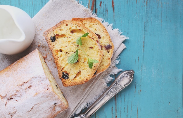 Tarta casera con pasas y nueces cortadas en trozos sobre un fondo azul