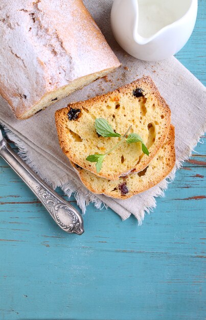 Tarta casera con pasas y nueces cortadas en trozos sobre un fondo azul