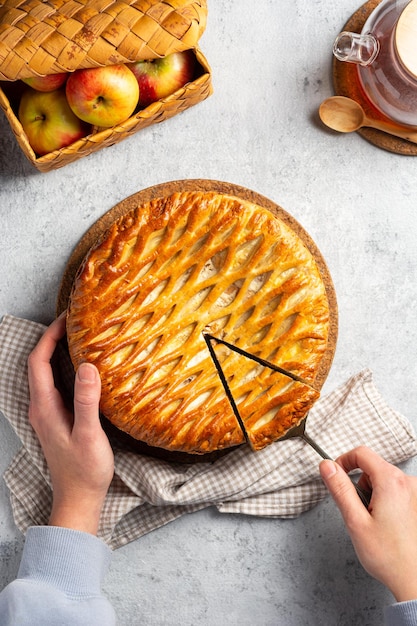 Tarta de celosía para hornear casera con requesón y manzana en la vista superior de la mano de la mujer Concepto de la hora del té