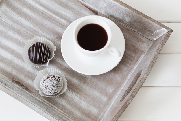 Tarta de chocolate dulce con taza en bandeja de madera