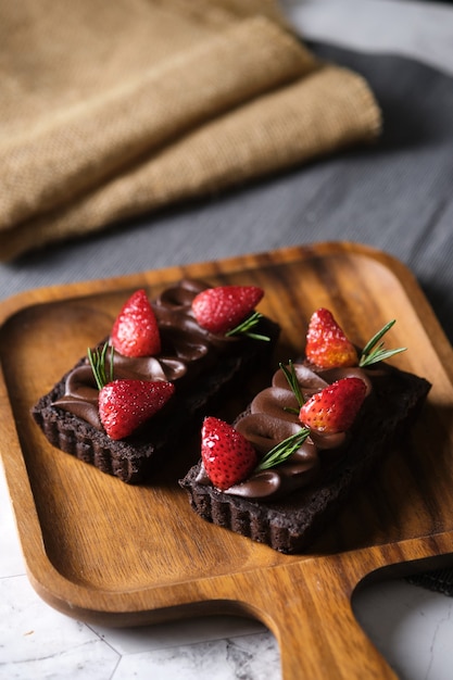 Tarta de chocolate rectangular con fresa en mesita de café