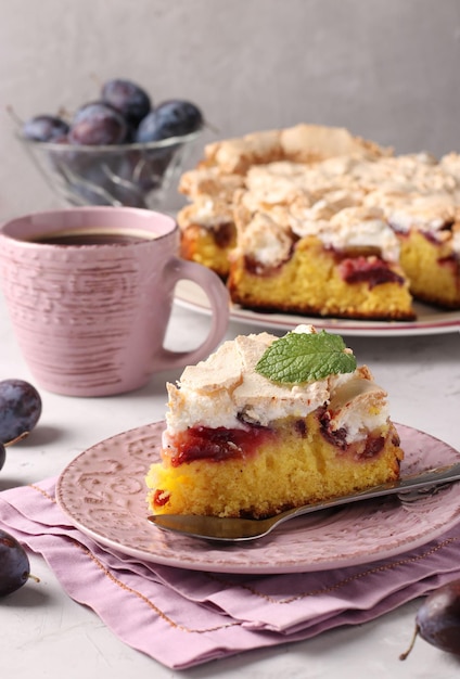 Tarta de ciruela casera cubierta con merengue dulce en un plato sobre un fondo claro cerrado