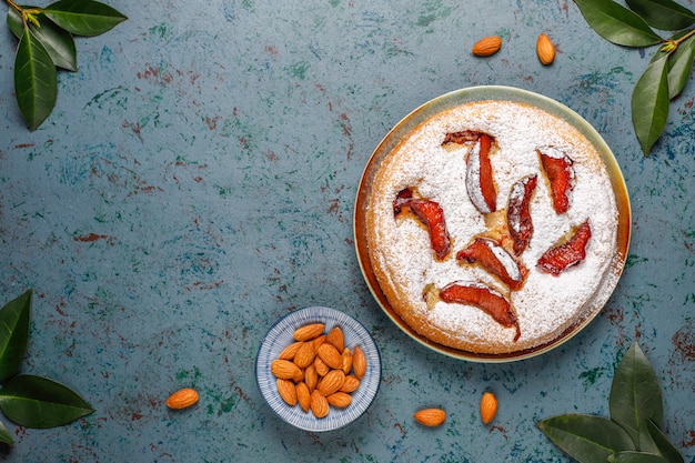 Tarta de ciruela rústica casera con azúcar en polvo y almendras, vista superior