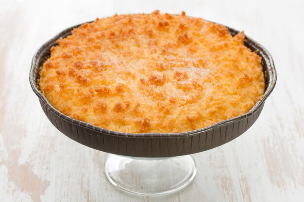 Tarta de coco en mesa de madera blanca