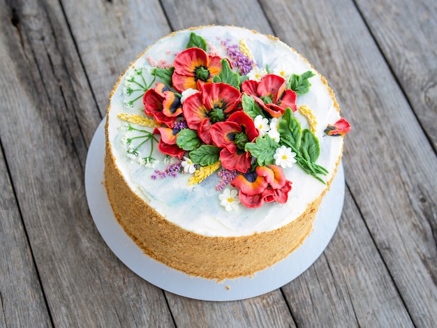 Tarta de crema blanca decorada con flores de crema de mantequilla