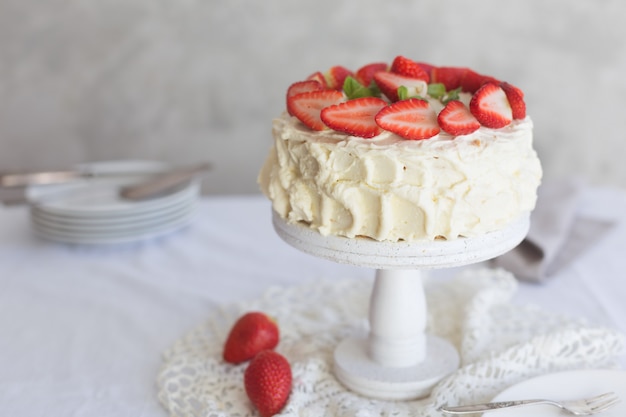 Tarta de crema blanca con fresa en la mesa blanca