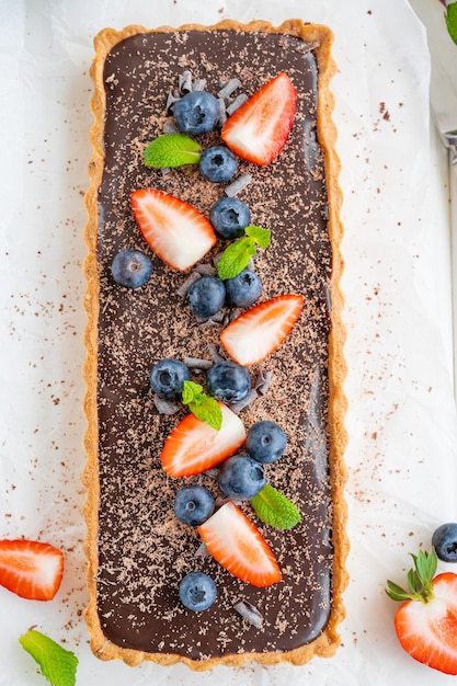 Tarta de crema de chocolate con arándanos frescos y fresas en la parte superior Postre de verano