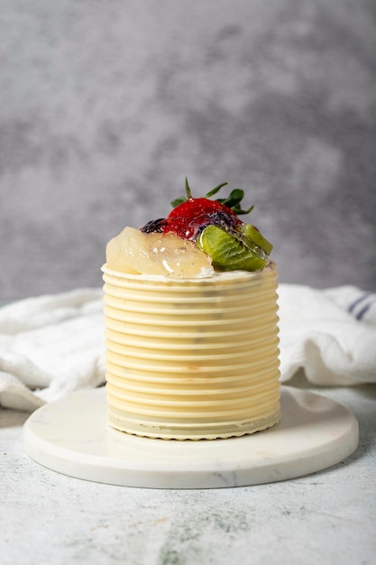 Tarta de crema rodeada de chocolate Tarta de chocolate y frutas sobre un fondo gris Fotografía de estudio Productos de panadería En primer plano