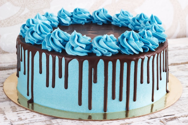 Foto tarta de cumpleaños con crema de chocolate gotea sobre un blanco