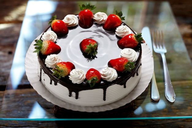 Tarta de cumpleaños de fresa con crema batida y chocolate