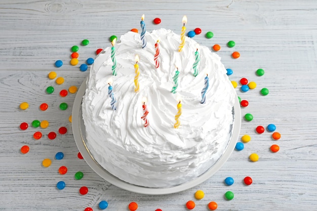 Tarta de cumpleaños con velas en mesa de madera