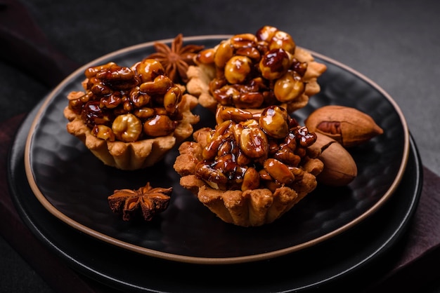 Tarta dulce y sabrosa con nueces y miel sobre un fondo de hormigón oscuro