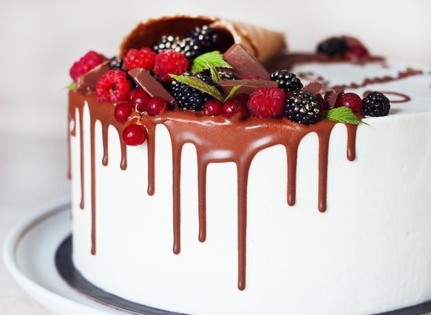 Tarta festiva con chocolate y bayas en una bocina