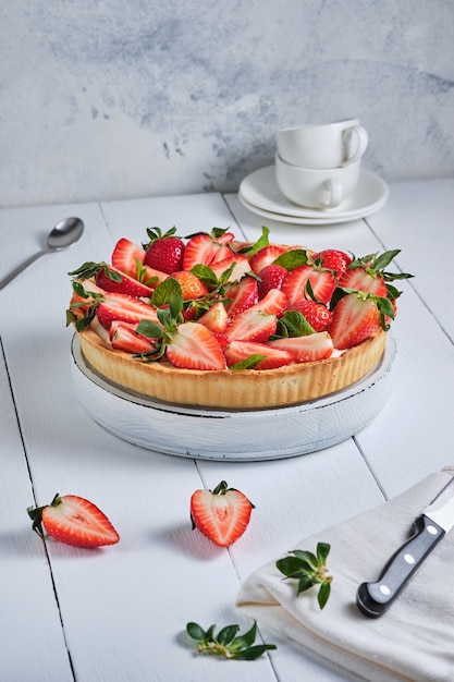 Tarta de fresa con crema de mantequilla sobre una mesa de madera blanca postre delicioso francés