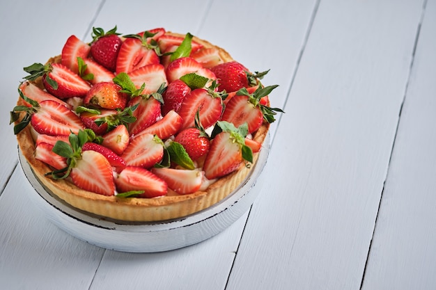 Tarta de fresa con crema de mantequilla sobre una mesa de madera blanca postre delicioso francés