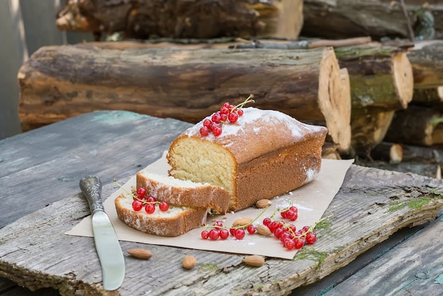 Tarta de frutas con grosellas rojas y almendras en una mesa de jardín