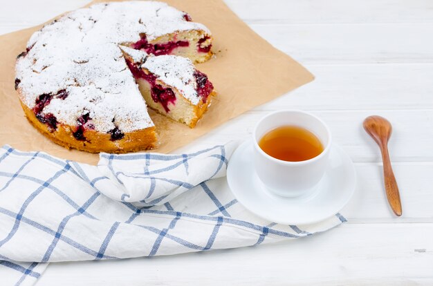 Tarta de frutas y té en una mesa de madera