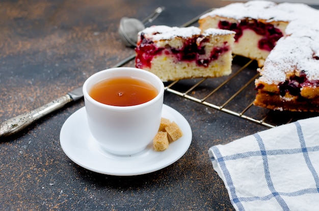 Tarta de frutas y té en una mesa de madera