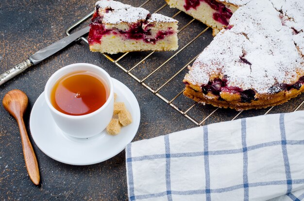 Tarta de frutas y té en una mesa de madera