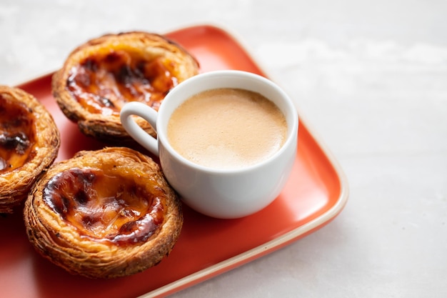 Tarta de huevo típica portuguesa pastel de nata con taza de café