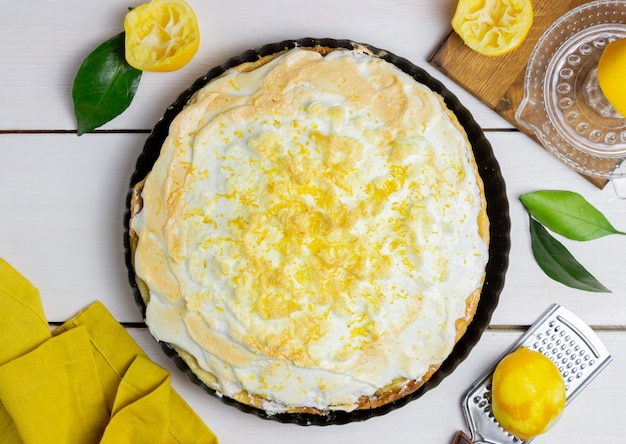 Foto tarta de limón con merengue sobre un fondo de madera.