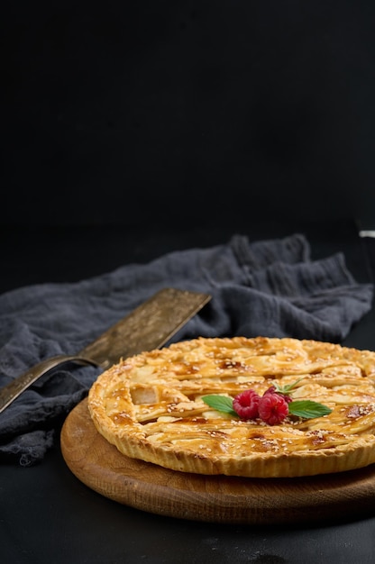 Tarta de manzana al horno redonda sobre una mesa negra