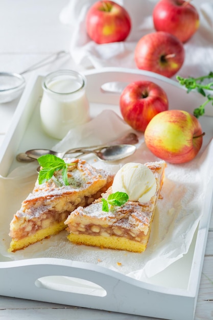 Tarta de manzana casera con helado de vainilla sobre mesa blanca