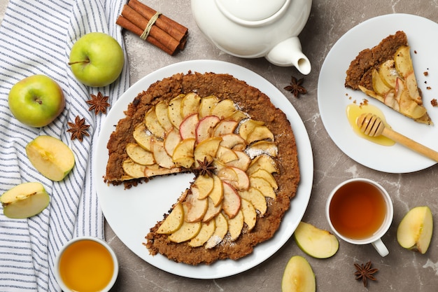 Tarta de manzana e ingredientes sobre fondo gris