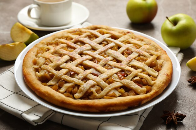 Tarta de manzana e ingredientes sobre fondo gris