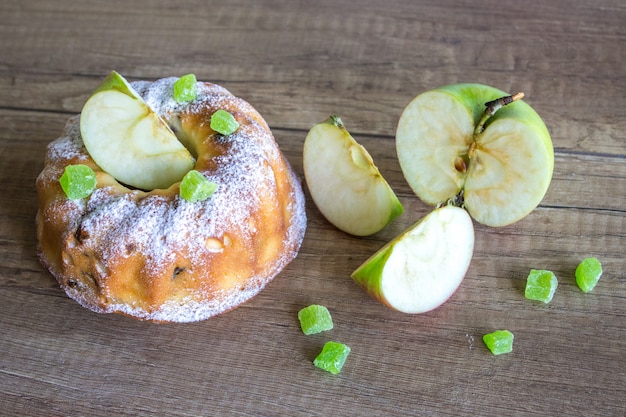 Tarta de manzana y manzana verde sobre una mesa de madera
